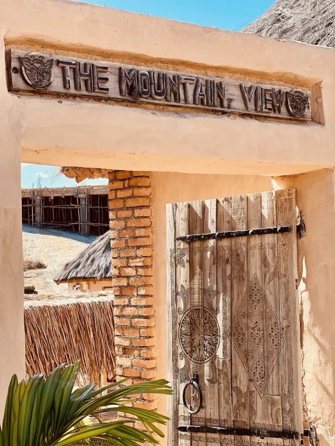 Entrée du The Mountain View Restaurant, avec porche et portail artisanal sculpté, près de la Réserve d’Anja à Ambalavao. Porche d’entrée du The Mountain View Restaurant avec portail sculpté par des artisans à Anja Reserve